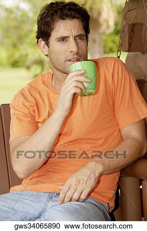 Close-up of a mid adult man holding a cup of tea View Large Photo Image Stock Image - Close-up of a mid adult man holding a cup of tea. Fotosearch