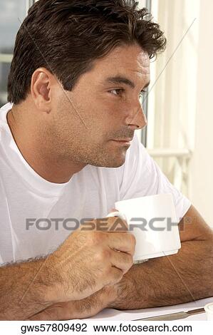 Close-up of a mid adult man holding a cup of coffee View Large Photo Image Stock Image - Close-up of a mid adult man holding a cup of coffee. Fotosearch