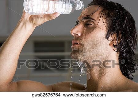 Close-up of a mid adult man pouring water on his face View Large Photo Image Picture - Close-up of a mid adult man pouring water on his face. Fotosearch