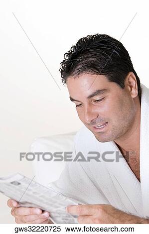 Stock Photography - Close-up of a mid adult man reading a newspaper. Fotosearch