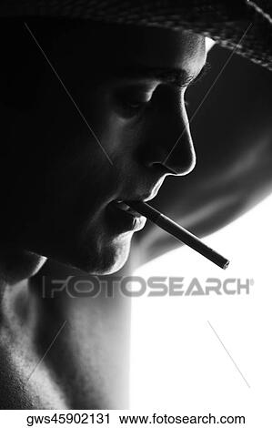Close-up of a mid adult man smoking a cigarette View Large Photo Image Stock Image - Close-up of a mid adult man smoking a cigarette. Fotosearch