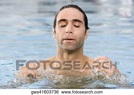 Stock Photograph - Close-up of a mid adult man swimming in a swimming pool. Fotosearch
