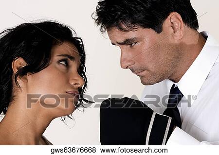 Stock Photo - Close-up of a mid adult man wearing boxing glove staring at a young woman. Fotosearch