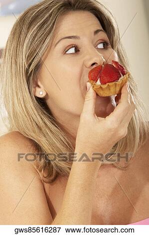 Close-up of a mid adult woman eating a strawberry tart View Large Photo Image Stock Photo - Close-up of a mid adult woman eating a strawberry tart. Fotosearch