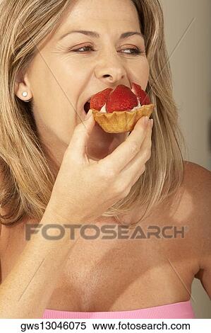 Close-up of a mid adult woman eating a strawberry tart View Large Photo Image Stock Photography - Close-up of a mid adult woman eating a strawberry tart. Fotosearch