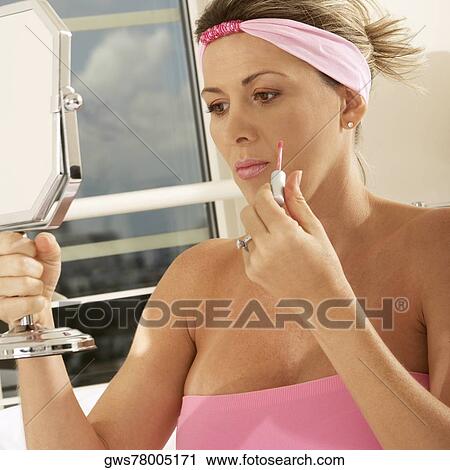Close-up of a mid adult woman holding a mirror and a lip liner View Large Photo Image Stock Image - Close-up of a mid adult woman holding a mirror and a lip liner. Fotosearch