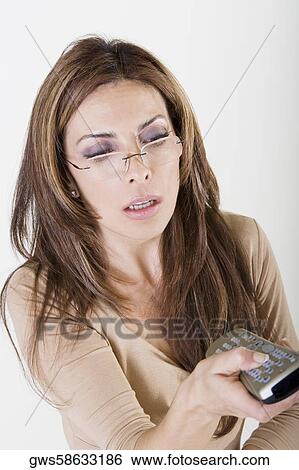 Close-up of a mid adult woman holding a remote control View Large Photo Image Stock Photograph - Close-up of a mid adult woman holding a remote control. Fotosearch