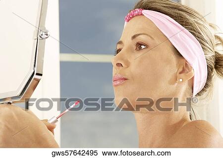 Close-up of a mid adult woman holding a mirror and a lip liner View Large Photo Image Stock Photography - Close-up of a mid adult woman holding a mirror and a lip liner. Fotosearch