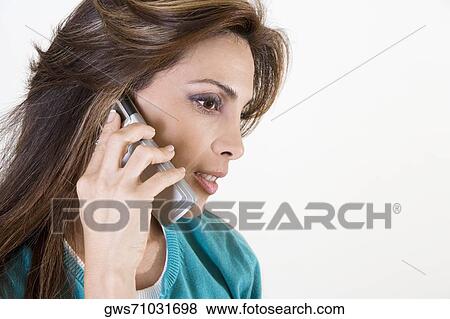 Stock Photo - Close-up of a mid adult woman talking on a mobile phone. Fotosearch