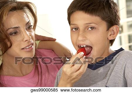 Close-up of a mother feeding her son a strawberry View Large Photo Image Stock Photography - Close-up of a mother feeding her son a strawberry. Fotosearch