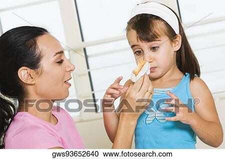 Close-up of a mother feeding her daughter View Large Photo Image Stock Image - Close-up of a mother feeding her daughter. Fotosearch