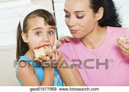 Close-up of a mother feeding her daughter View Large Photo Image Stock Photo - Close-up of a mother feeding her daughter. Fotosearch