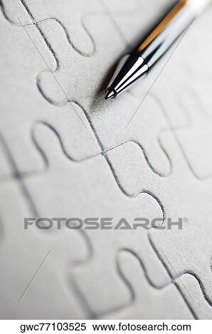 Stock Photography - Close-up of a pen on a jigsaw puzzle. Fotosearch