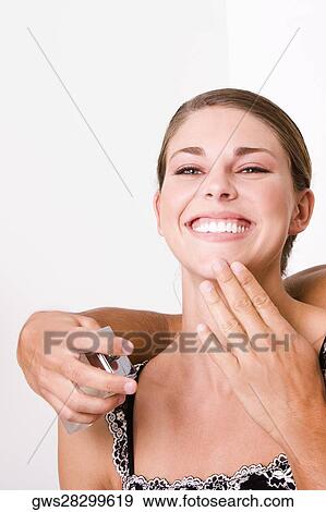 Close-up of a person's hand spraying perfume on a young woman View Large Photo Image Stock Photo - Close-up of a person's hand spraying perfume on a young woman. Fotosearch