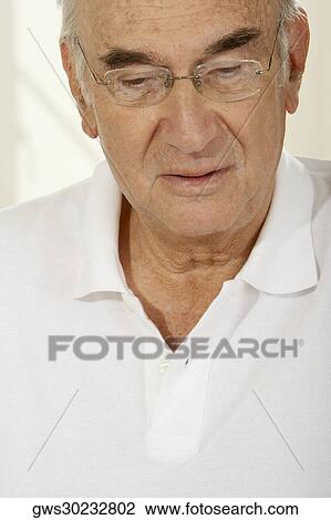 Close-up of a senior man looking down View Large Photo Image Stock Image - Close-up of a senior man looking down. Fotosearch