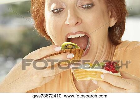 Close-up of a senior woman eating a fruit tart View Large Photo Image Stock Image - Close-up of a senior woman eating a fruit tart. Fotosearch