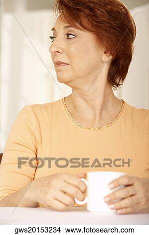 Close-up of a senior woman holding a cup of coffee and looking sideways View Large Photo Image Picture - Close-up of a senior woman holding a cup of coffee and looking sideways. Fotosearch