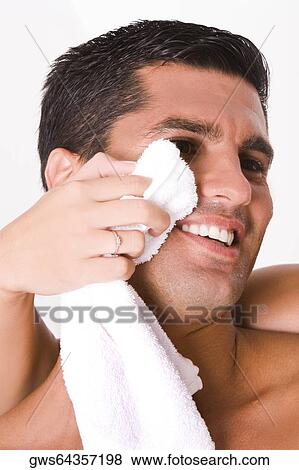 Close-up of a woman's hand wiping a mid adult man's face with a towel View Large Photo Image Stock Photo - Close-up of a woman's hand wiping a mid adult man's face with a towel. Fotosearch