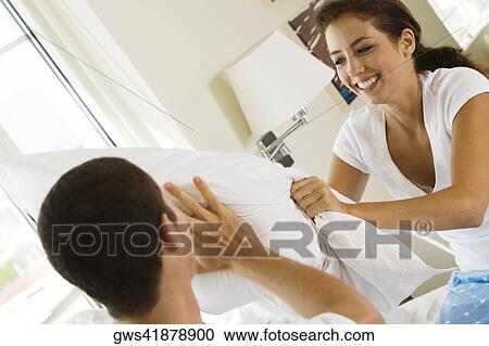 Close-up of a young couple having a pillow fight View Large Photo Image Stock Image - Close-up of a young couple having a pillow fight. Fotosearch