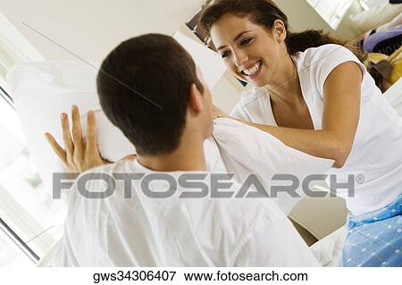 Stock Photo - Close-up of a young couple having a pillow fight. Fotosearch
