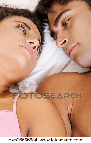 Close-up of a young couple looking at each other on a bed View Large Photo Image Picture - Close-up of a young couple looking at each other on a bed. Fotosearch