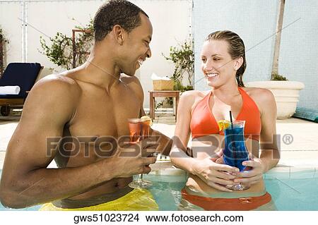 Close-up of a young couple looking at each other in a swimming pool View Large Photo Image Picture - Close-up of a young couple looking at each other in a swimming pool. Fotosearch