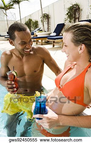 Stock Photography - Close-up of a young couple looking at each other in a swimming pool. Fotosearch