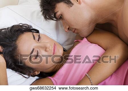 Close-up of a young couple lying on the bed View Large Photo Image Picture - Close-up of a young couple lying on the bed. Fotosearch