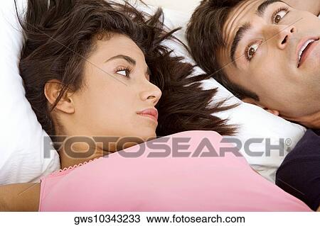 Close-up of a young couple lying on the bed View Large Photo Image Stock Image - Close-up of a young couple lying on the bed. Fotosearch