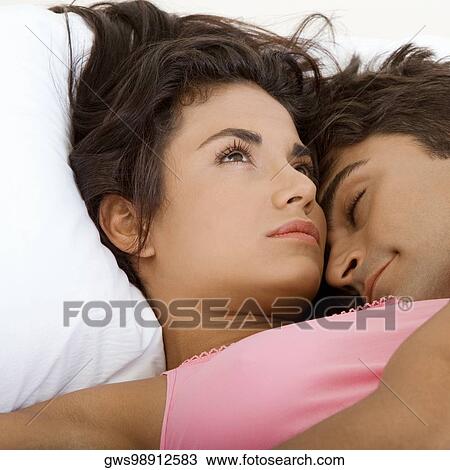 Close-up of a young couple lying on the bed View Large Photo Image Stock Image - Close-up of a young couple lying on the bed. Fotosearch