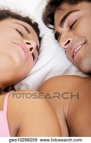 Close-up of a young couple lying on the bed View Large Photo Image Stock Photo - Close-up of a young couple lying on the bed. Fotosearch