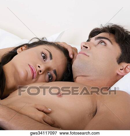 Close-up of a young couple lying on the bed View Large Photo Image Stock Photo - Close-up of a young couple lying on the bed. Fotosearch