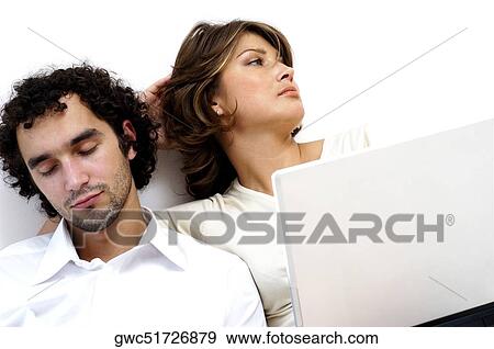 Close-up of a young couple sitting against a wall View Large Photo Image Stock Photo - Close-up of a young couple sitting against a wall. Fotosearch