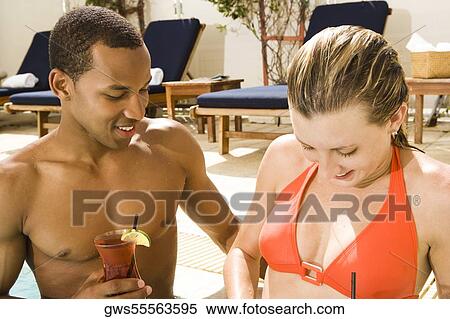 Close-up of a young couple smiling in a swimming pool View Large Photo Image Stock Photography - Close-up of a young couple smiling in a swimming pool. Fotosearch