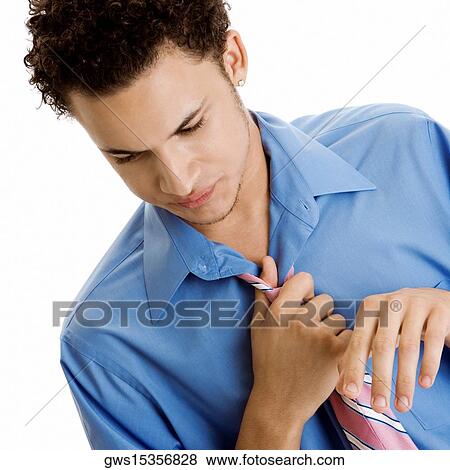 Close-up of a young man adjusting his tie View Large Photo Image Stock Photo - Close-up of a young man adjusting his tie. Fotosearch