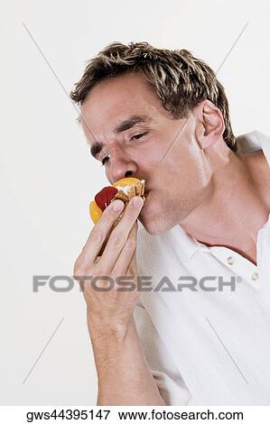 Close-up of a young man eating a strawberry tart View Large Photo Image Stock Photo - Close-up of a young man eating a strawberry tart. Fotosearch