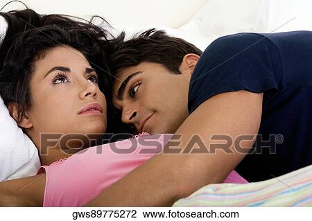 Close-up of a young man embracing a young woman in bed View Large Photo Image Stock Image - Close-up of a young man embracing a young woman in bed. Fotosearch