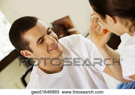 Stock Image - Close-up of a young man feeding a young woman cherries. Fotosearch