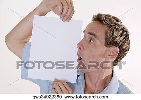 Close-up of a young man holding a blank placard View Large Photo Image Stock Image - Close-up of a young man holding a blank placard. Fotosearch