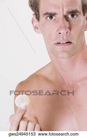 Close-up of a young man holding a condom View Large Photo Image Stock Image - Close-up of a young man holding a condom. Fotosearch