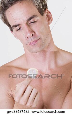 Close-up of a young man holding a condom View Large Photo Image Stock Image - Close-up of a young man holding a condom. Fotosearch