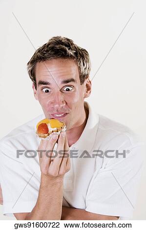 Close-up of a young man holding a strawberry tart View Large Photo Image Stock Image - Close-up of a young man holding a strawberry tart. Fotosearch