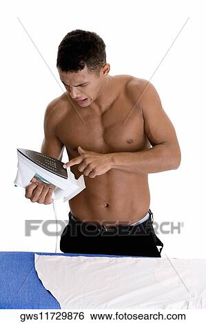 Close-up of a young man holding an iron View Large Photo Image Stock Photograph - Close-up of a young man holding an iron. Fotosearch