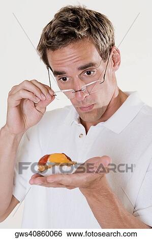 Close-up of a young man looking at a strawberry tart View Large Photo Image Stock Photograph - Close-up of a young man looking at a strawberry tart. Fotosearch