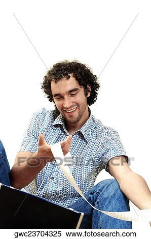 Close-up of a young man looking at a bill in front of a laptop View Large Photo Image Stock Photography - Close-up of a young man looking at a bill in front of a laptop. Fotosearch