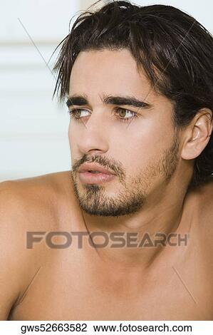 Close-up of a young man looking sideways View Large Photo Image Stock Image - Close-up of a young man looking sideways. Fotosearch