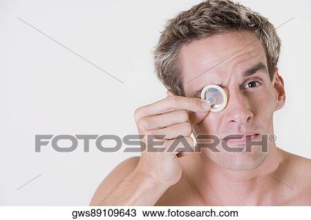Close-up of a young man looking through a condom View Large Photo Image Stock Image - Close-up of a young man looking through a condom. Fotosearch