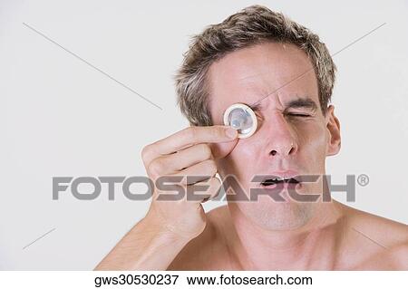 Close-up of a young man looking through a condom View Large Photo Image Stock Photo - Close-up of a young man looking through a condom. Fotosearch