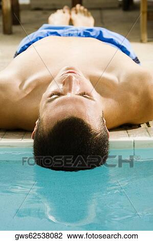 Close-up of a young man lying at the poolside View Large Photo Image Stock Image - Close-up of a young man lying at the poolside. Fotosearch
