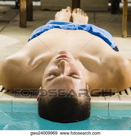 Close-up of a young man lying at the poolside View Large Photo Image Stock Photo - Close-up of a young man lying at the poolside. Fotosearch